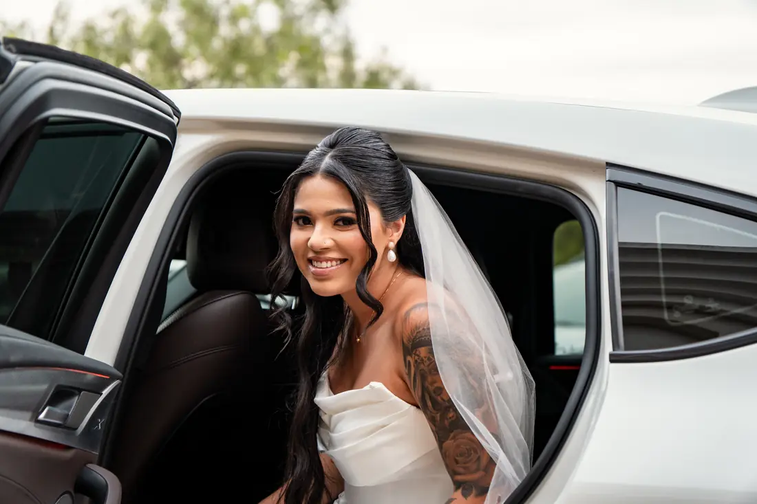 Noiva sorrindo dentro do carro antes da cerimônia